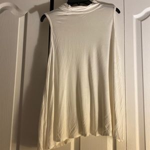 All white Discreet sleeveless round neck blouse.